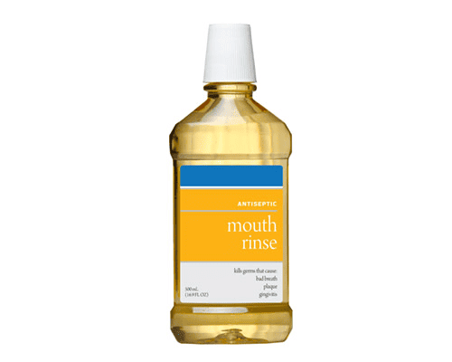 Bottle of mouth rinse with a white cap on a white background